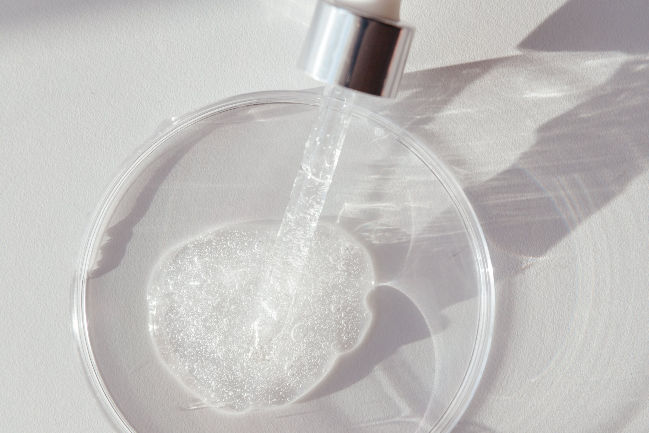 Pipette with Sample of Gels Cosmetic Product in Petri Dish on white background